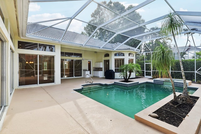 view of pool featuring glass enclosure, an in ground hot tub, and a patio area