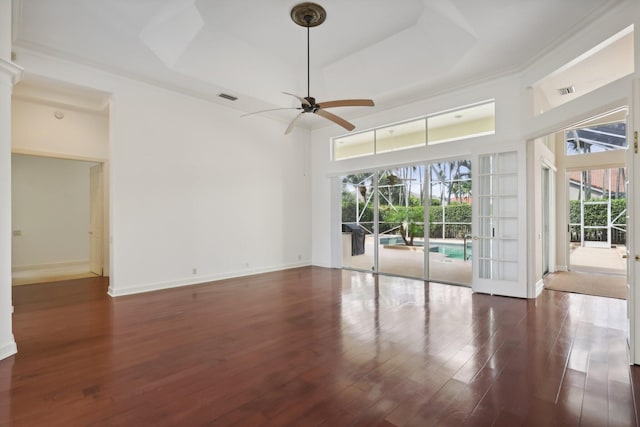 spare room with a raised ceiling, ceiling fan, french doors, and dark hardwood / wood-style flooring