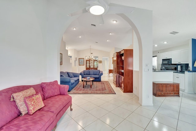 tiled living room with lofted ceiling and ceiling fan with notable chandelier