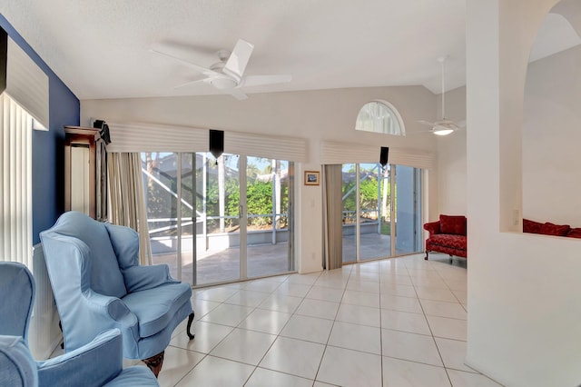 interior space with a textured ceiling, ceiling fan, vaulted ceiling, and light tile patterned floors