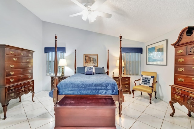 bedroom with ceiling fan, vaulted ceiling, a textured ceiling, and light tile patterned floors