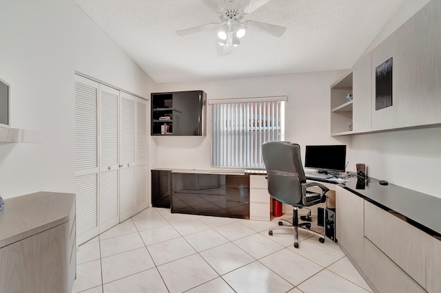 home office with ceiling fan, lofted ceiling, and light tile patterned floors