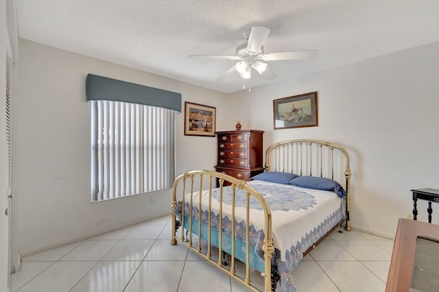 bedroom featuring a textured ceiling, ceiling fan, and light tile patterned floors