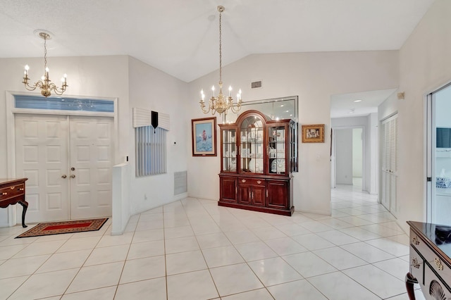 entryway with a notable chandelier, vaulted ceiling, and light tile patterned flooring