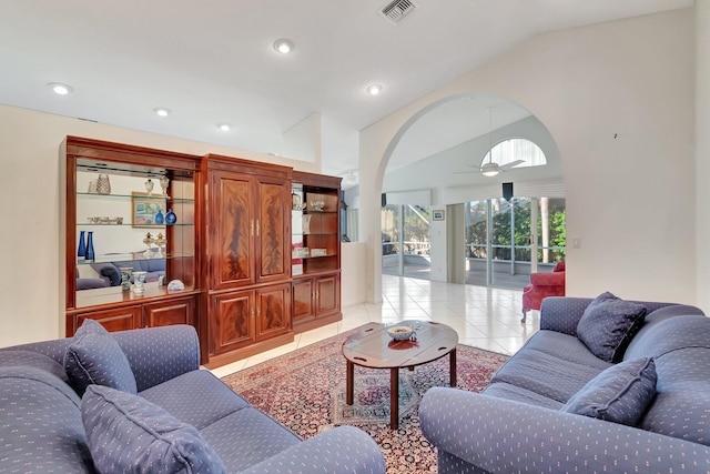 living room featuring vaulted ceiling, ceiling fan, and light tile patterned floors