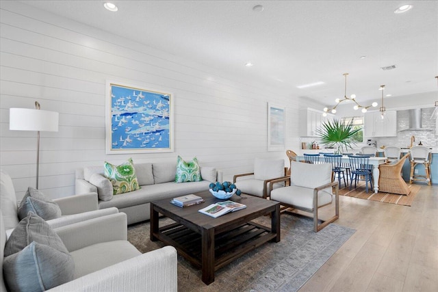 living room with a notable chandelier and light hardwood / wood-style flooring