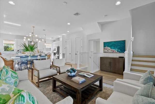 living room featuring an inviting chandelier and light wood-type flooring