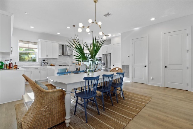 dining area featuring light hardwood / wood-style floors and a chandelier