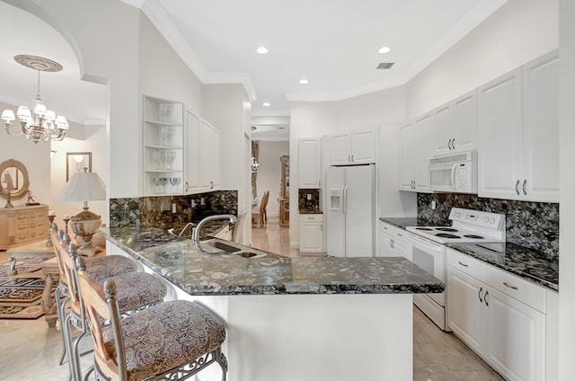 kitchen featuring white appliances, white cabinets, kitchen peninsula, and sink