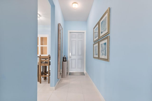 hallway with light tile patterned flooring and baseboards