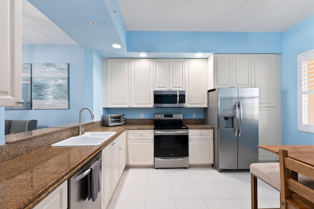 kitchen with light tile patterned floors, recessed lighting, appliances with stainless steel finishes, white cabinetry, and a sink