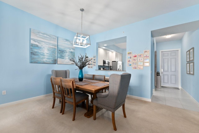 dining space with baseboards, light tile patterned floors, a chandelier, and light colored carpet