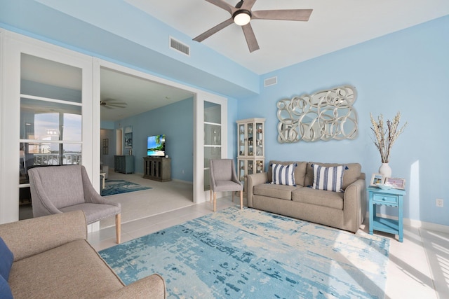 living area featuring ceiling fan, visible vents, and tile patterned floors