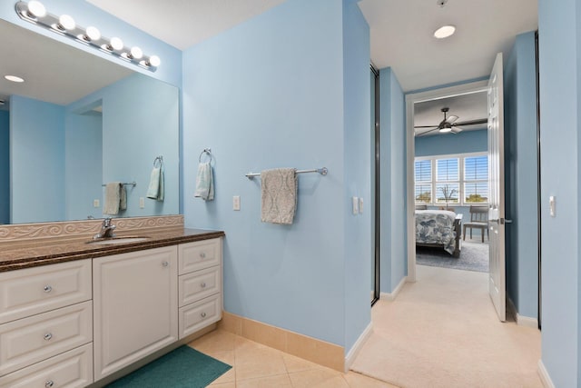 bathroom featuring ensuite bathroom, tile patterned flooring, a ceiling fan, vanity, and baseboards