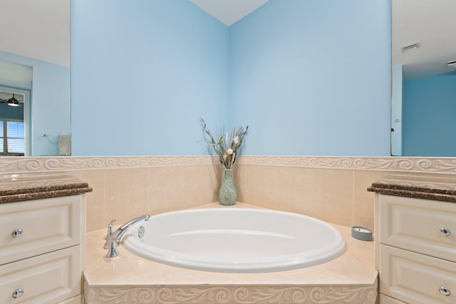 bathroom featuring visible vents, a garden tub, ceiling fan, and vanity