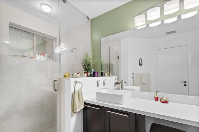 bathroom with a shower with door and vanity