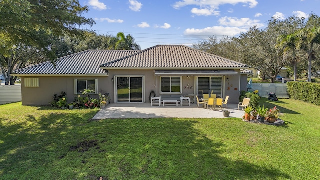 rear view of property featuring a lawn and a patio