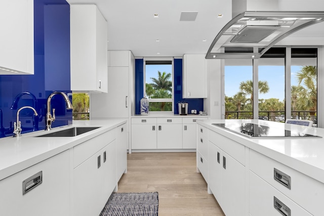 kitchen featuring sink, white cabinets, black electric stovetop, and plenty of natural light