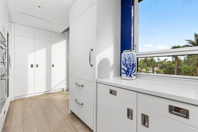 kitchen with white cabinets and light wood-type flooring