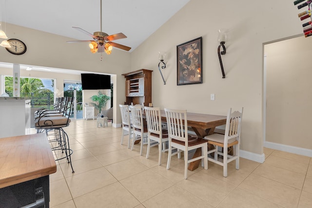 dining room with ceiling fan, light tile patterned floors, and vaulted ceiling