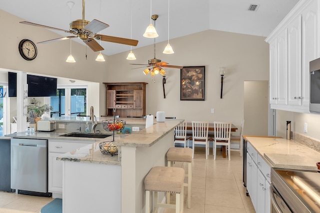 kitchen featuring light tile patterned floors, white cabinetry, stainless steel appliances, lofted ceiling, and sink