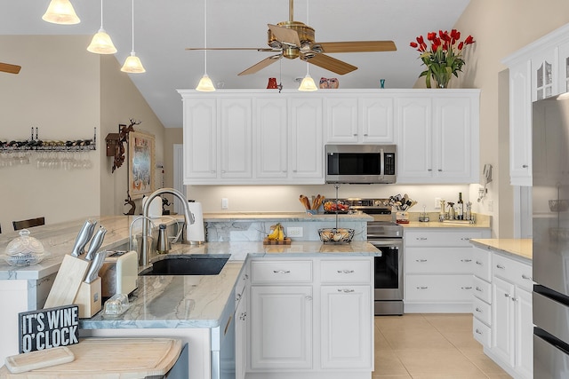 kitchen with pendant lighting, appliances with stainless steel finishes, white cabinetry, sink, and light tile patterned floors