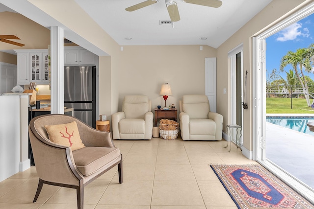 sitting room with ceiling fan, a pool, and light tile patterned flooring