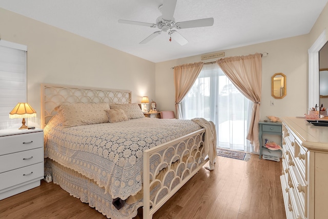 bedroom with a textured ceiling, ceiling fan, and wood-type flooring