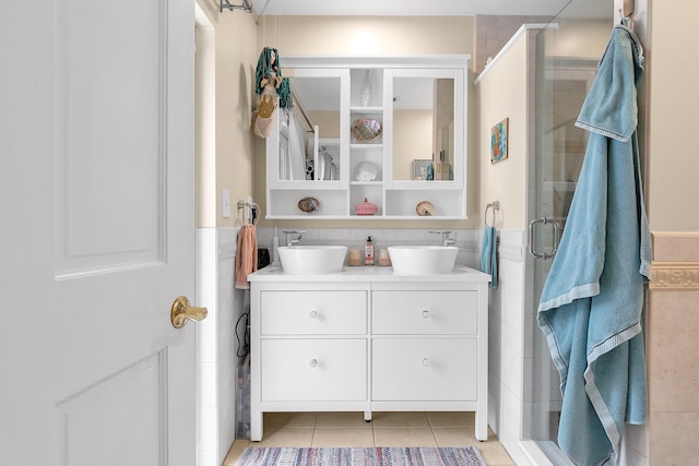 bathroom with tile walls, walk in shower, vanity, and tile patterned flooring