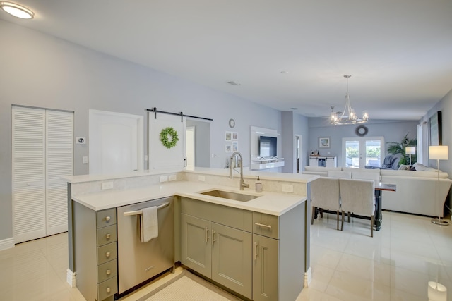 kitchen with sink, dishwasher, gray cabinetry, decorative light fixtures, and a barn door