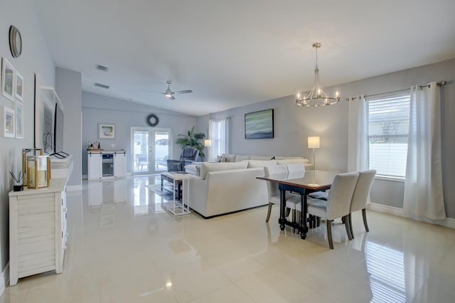 tiled living room with wine cooler, lofted ceiling, ceiling fan with notable chandelier, and french doors