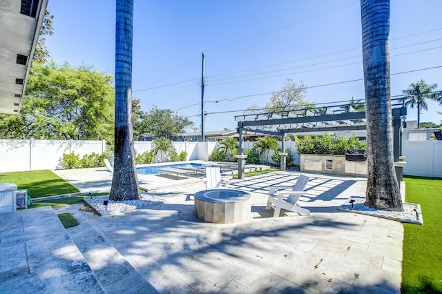 view of patio / terrace with exterior kitchen, an outdoor fire pit, a pergola, and a fenced in pool