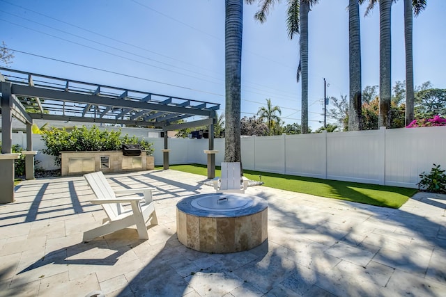 view of patio featuring area for grilling, a pergola, and an outdoor fire pit