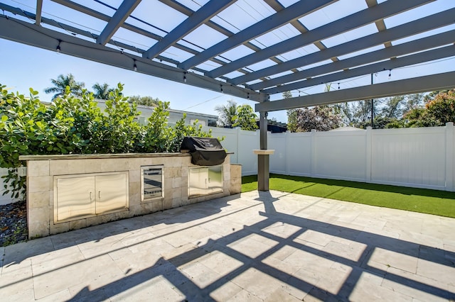 view of patio featuring a grill, a pergola, and exterior kitchen