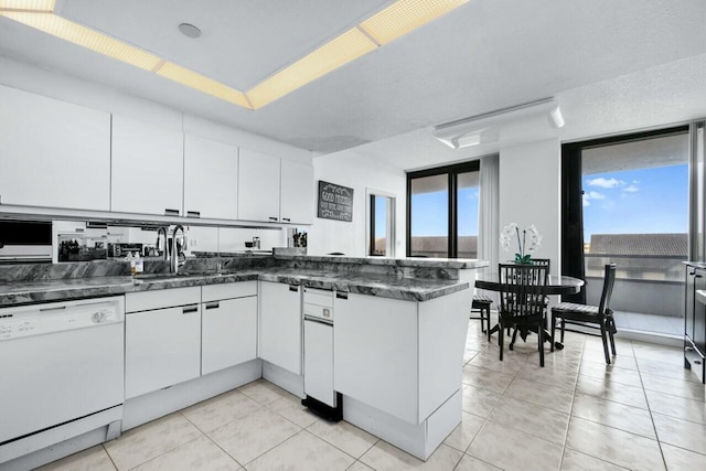 100 Lakeshore Dr Unit 252, North Palm Beach, FL 33408 - kitchen with sink, light tile patterned floors, white cabinetry, and dishwasher