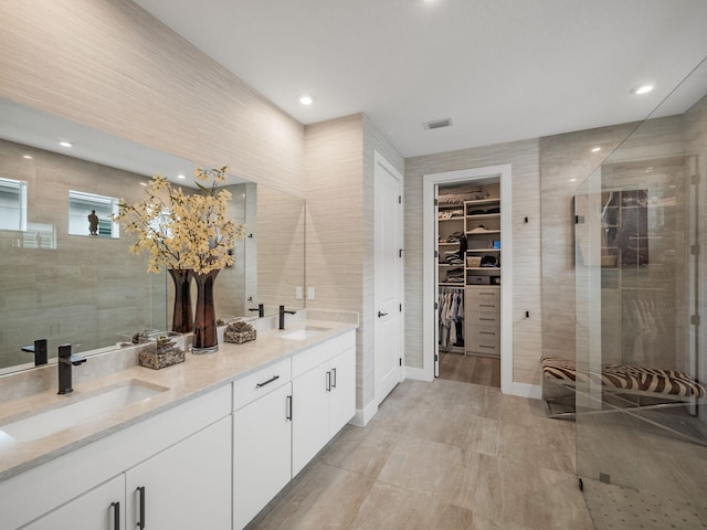 bathroom featuring tile walls, vanity, and a tile shower