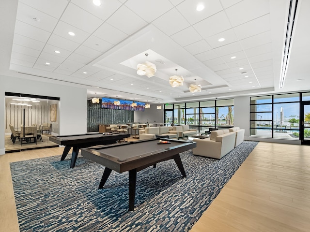 recreation room with wood-type flooring, billiards, and a tray ceiling