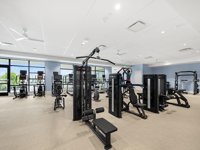 gym featuring plenty of natural light, light colored carpet, and ceiling fan