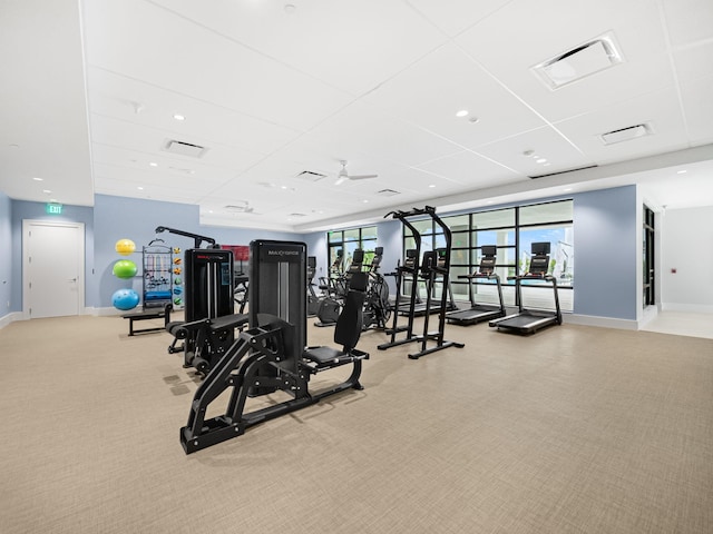 workout area featuring light carpet, a wealth of natural light, and a paneled ceiling