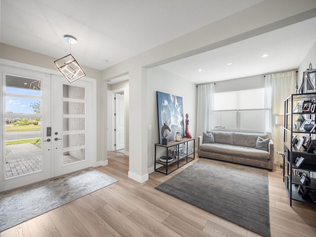 entryway featuring a notable chandelier, light hardwood / wood-style flooring, and french doors