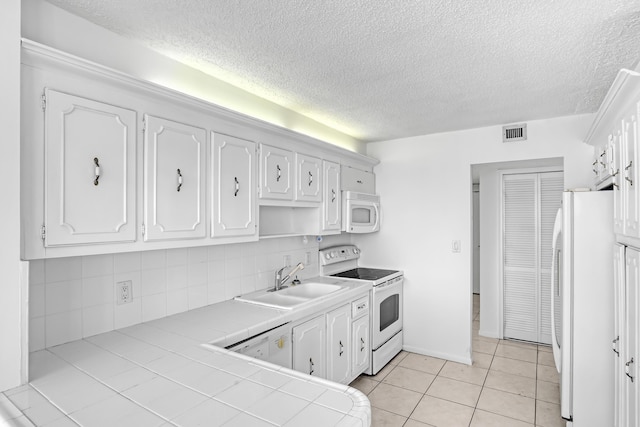 kitchen with sink, white cabinetry, white appliances, tile counters, and backsplash