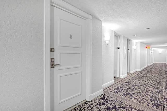 hallway with wood-type flooring and a textured ceiling