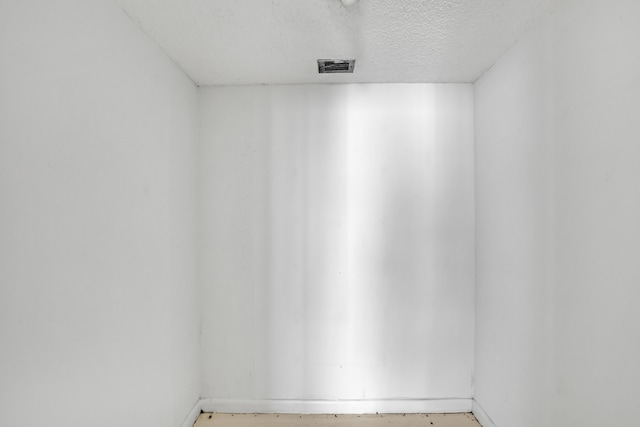 unfurnished room featuring a textured ceiling