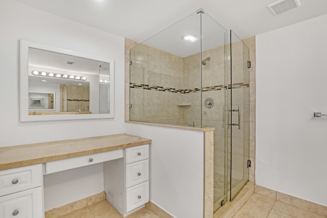 bathroom featuring vanity, tile patterned flooring, and walk in shower