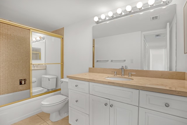 full bathroom featuring toilet, vanity, tile patterned floors, and bath / shower combo with glass door