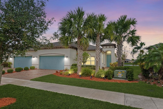 mediterranean / spanish house with a garage and a lawn