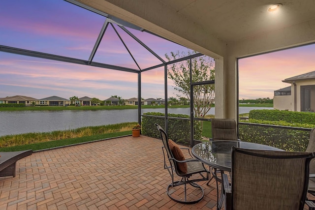 patio terrace at dusk with glass enclosure and a water view