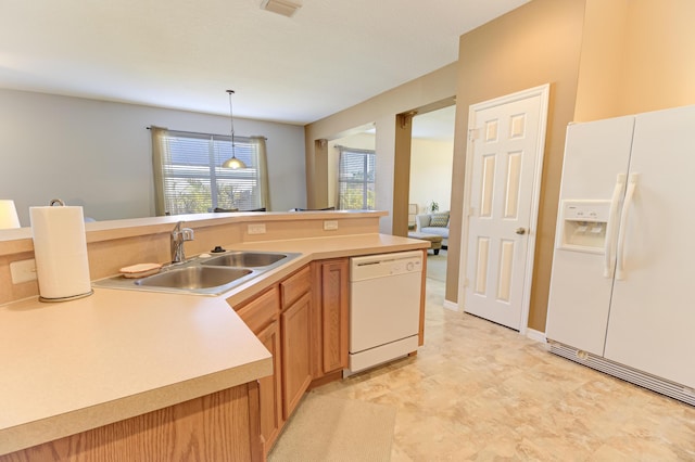 kitchen with sink, white appliances, and pendant lighting