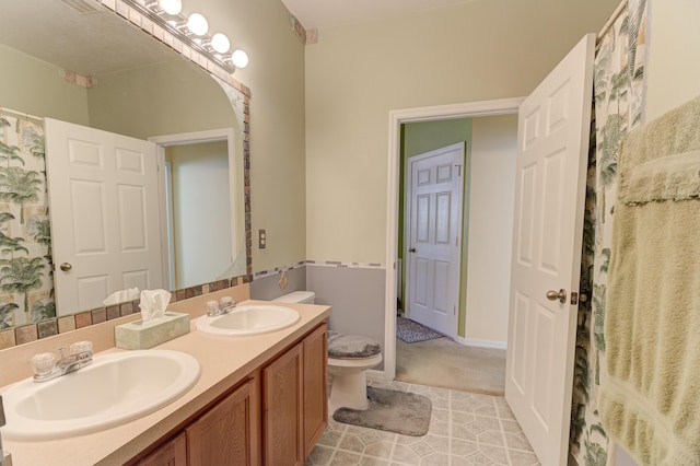 bathroom featuring toilet, vanity, and tile patterned flooring