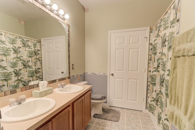 bathroom featuring toilet, tile patterned flooring, vanity, and walk in shower